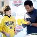 Michigan fans Vito Peraino and his son Dominick, 14, both of Cincinnati, meet with former Michigan football player Dhani Jones as he signs autographs during the Allstate Fan Fest in New Orleans, LA, on Monday.  Melanie Maxwell I AnnArbor.com